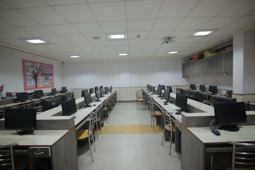 best private school in rohini,a teacher teaching the students in computer lab