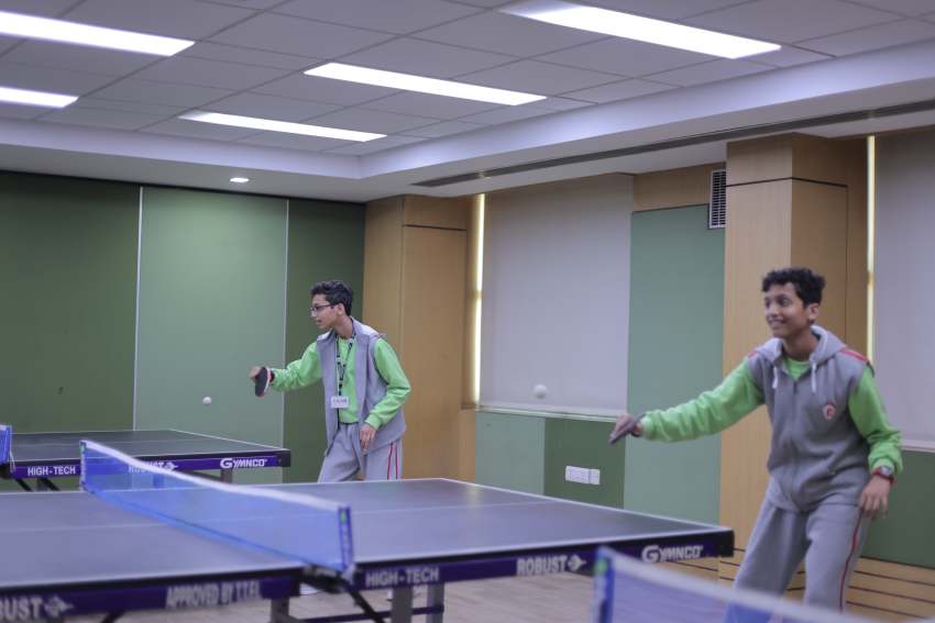the image shows team of girl studnets playing table tennies, school best in indoor games
